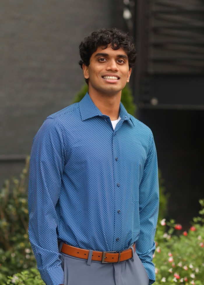 Abhay Tharakan, standing outdoors in a blue patterned shirt